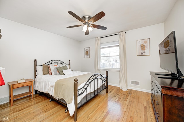 bedroom featuring visible vents, light wood-style flooring, a ceiling fan, and baseboards