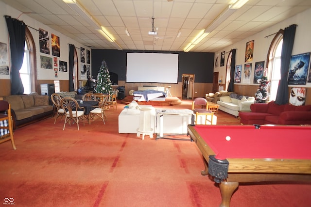 game room with carpet flooring, a paneled ceiling, and a wainscoted wall