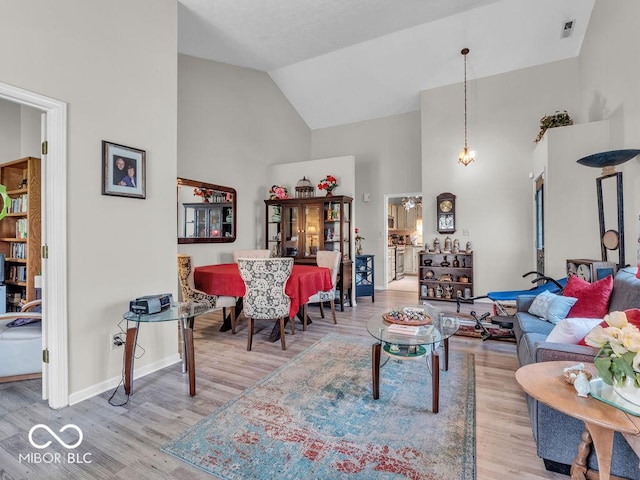 6556 Aintree Ter, Indianapolis, IN 46250 - living room featuring visible vents, high vaulted ceiling, wood finished floors, and baseboards
