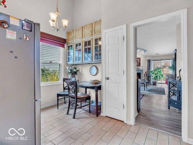 6556 Aintree Ter, Indianapolis, IN 46250 - dining space with a towering ceiling, an inviting chandelier, baseboards, and light wood-style floors