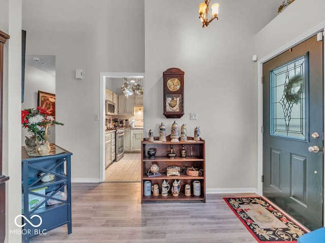 6556 Aintree Ter, Indianapolis, IN 46250 - foyer with an inviting chandelier, light wood finished floors, and baseboards