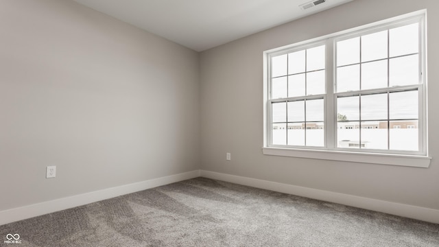 unfurnished room with carpet flooring, visible vents, and baseboards