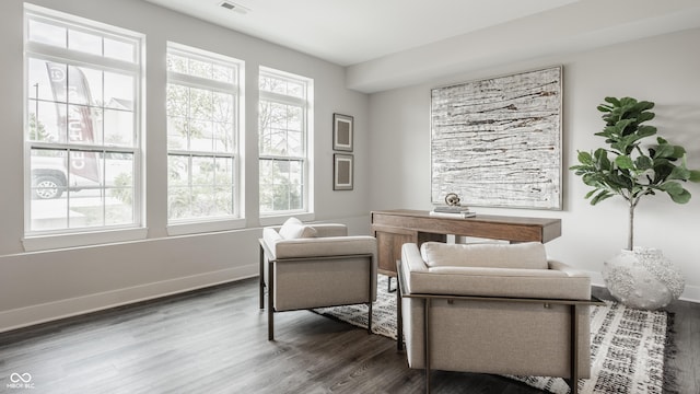 living area with visible vents, baseboards, and wood finished floors