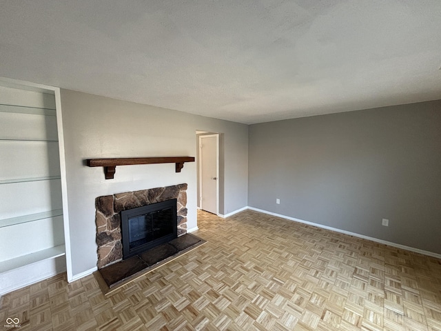 unfurnished living room with baseboards, a textured ceiling, and a fireplace