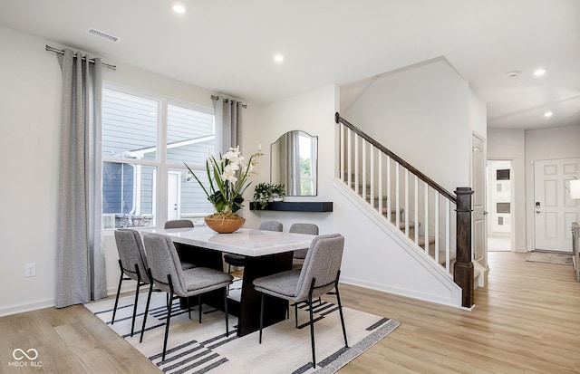 dining space with light wood finished floors, visible vents, baseboards, stairway, and recessed lighting