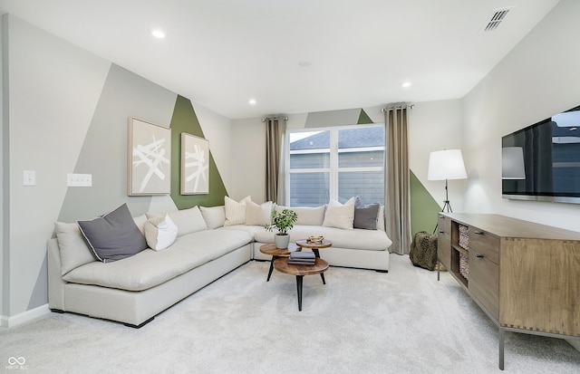 living room with recessed lighting, visible vents, and light colored carpet