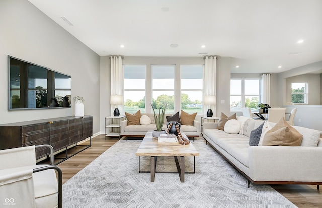 living area with recessed lighting, wood finished floors, and baseboards