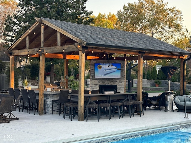 view of patio featuring a gazebo, an outdoor pool, and outdoor dry bar