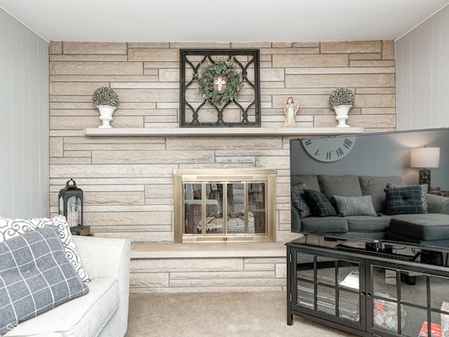 living room with carpet floors, wood walls, and a fireplace