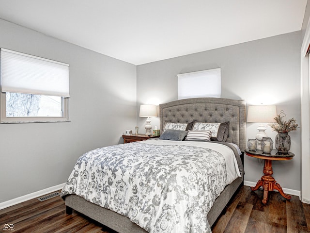 bedroom featuring visible vents, baseboards, and wood finished floors