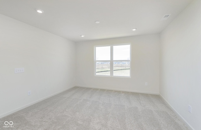 spare room featuring recessed lighting, visible vents, baseboards, and light carpet