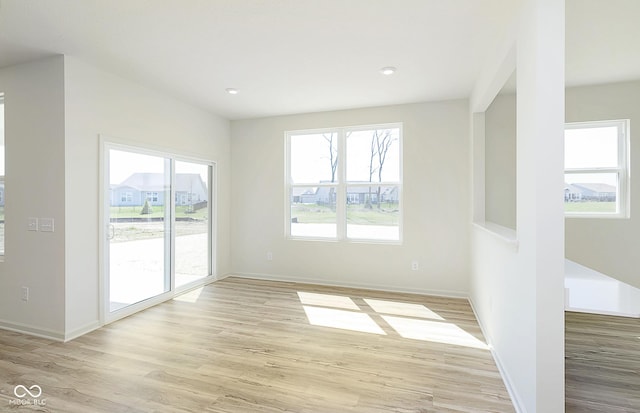 spare room with recessed lighting, light wood-style floors, and baseboards