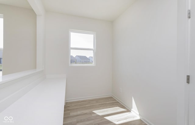 empty room featuring light wood finished floors and baseboards