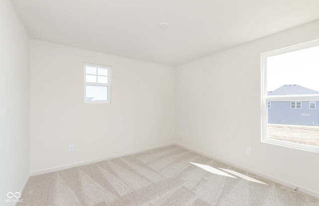 carpeted empty room featuring baseboards