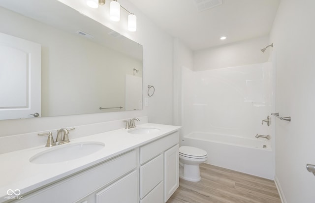 full bath with double vanity, visible vents, wood finished floors, and a sink