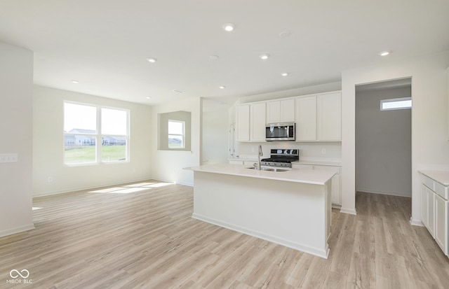 kitchen featuring a sink, stainless steel appliances, light wood-style floors, and light countertops