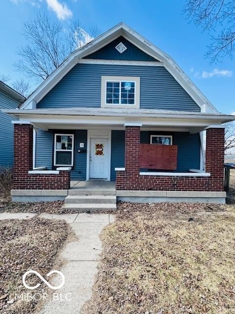 view of front of home with brick siding and covered porch