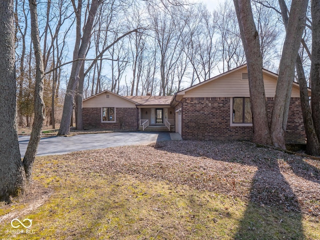 view of front of property featuring brick siding, concrete driveway, and an attached garage