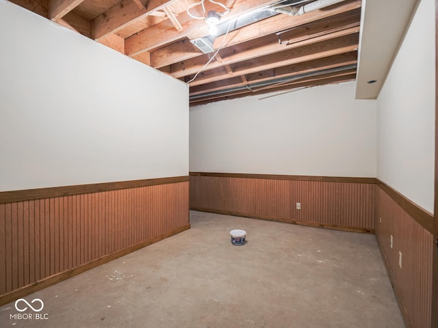 unfinished basement with wood walls and wainscoting