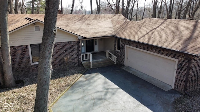 ranch-style home with brick siding, an attached garage, and a shingled roof