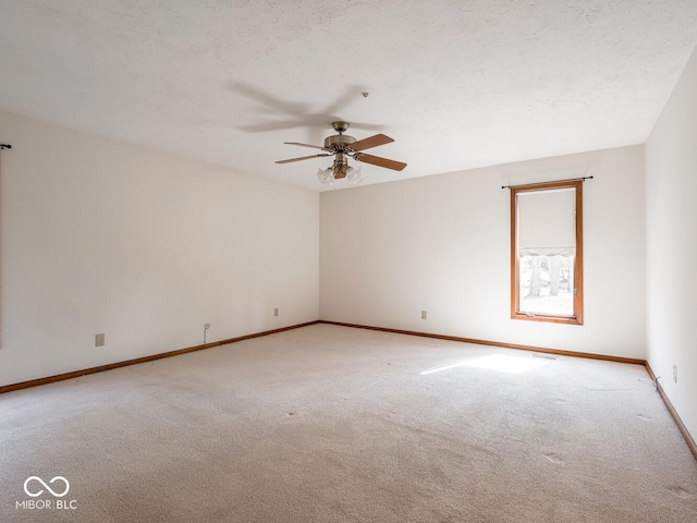 spare room featuring baseboards, light colored carpet, a textured ceiling, and a ceiling fan