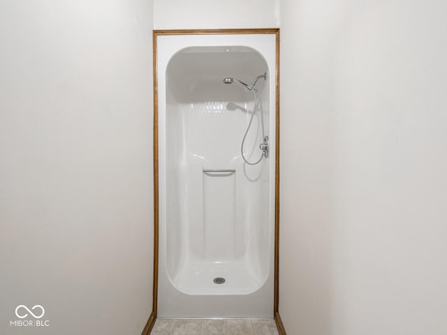 bathroom featuring a shower and baseboards