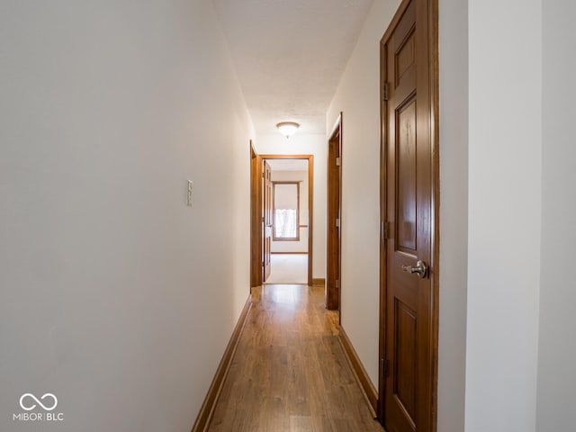 hallway with light wood-style floors and baseboards