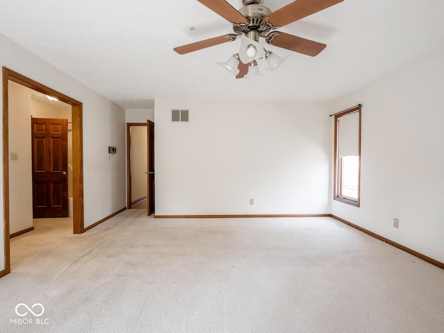 empty room featuring visible vents, baseboards, and light colored carpet