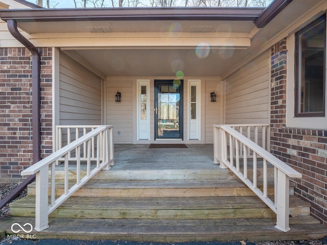 view of exterior entry with brick siding