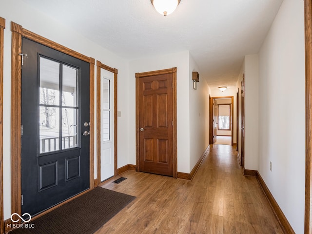 foyer featuring visible vents, light wood-type flooring, and baseboards