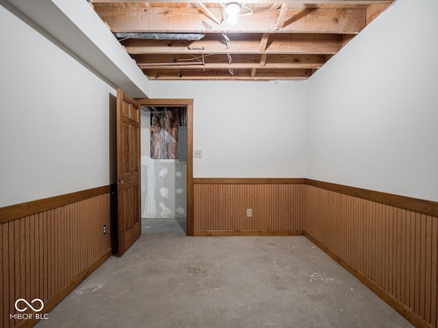 basement featuring wainscoting and wood walls