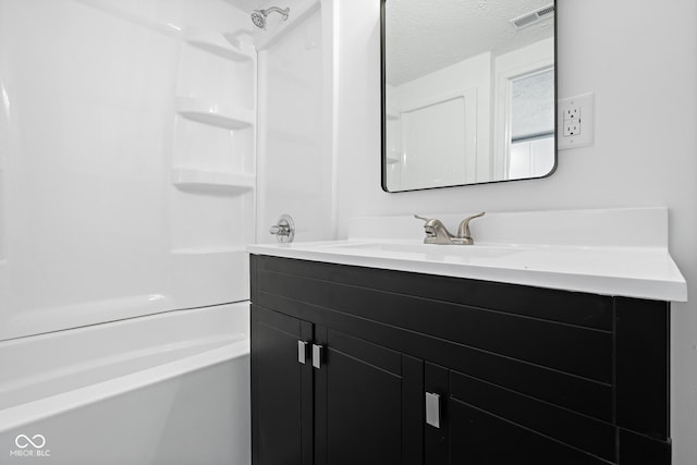 full bathroom featuring shower / tub combination, visible vents, a textured ceiling, and vanity