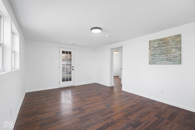 spare room featuring wood finished floors and baseboards