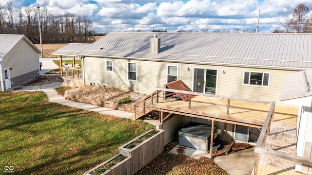 back of house featuring a garden, a lawn, and a deck