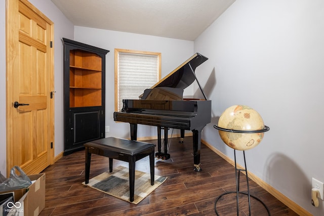 sitting room with dark wood-type flooring and baseboards