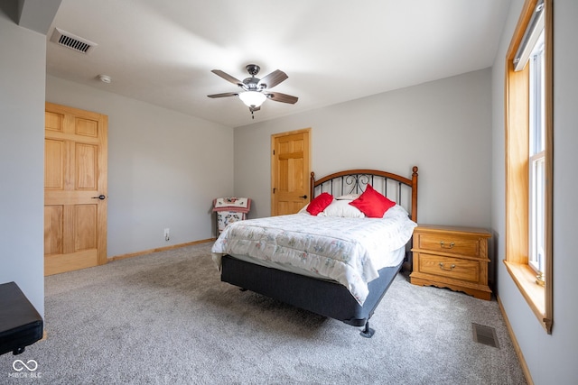 carpeted bedroom featuring visible vents, baseboards, and a ceiling fan