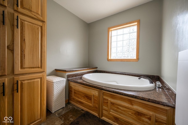 full bathroom featuring a bath and stone finish floor