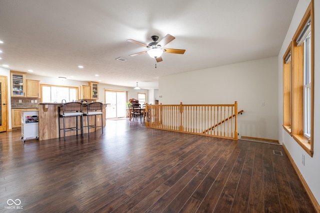 unfurnished living room with dark wood-style floors, a ceiling fan, visible vents, baseboards, and recessed lighting