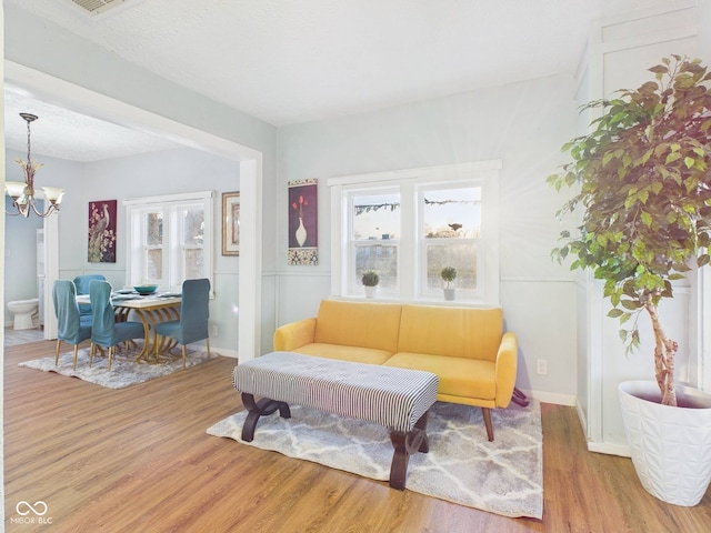 living area with an inviting chandelier and wood finished floors