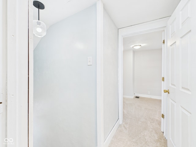 corridor with baseboards, light carpet, and visible vents