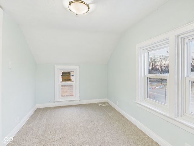 additional living space featuring visible vents, baseboards, carpet flooring, and vaulted ceiling