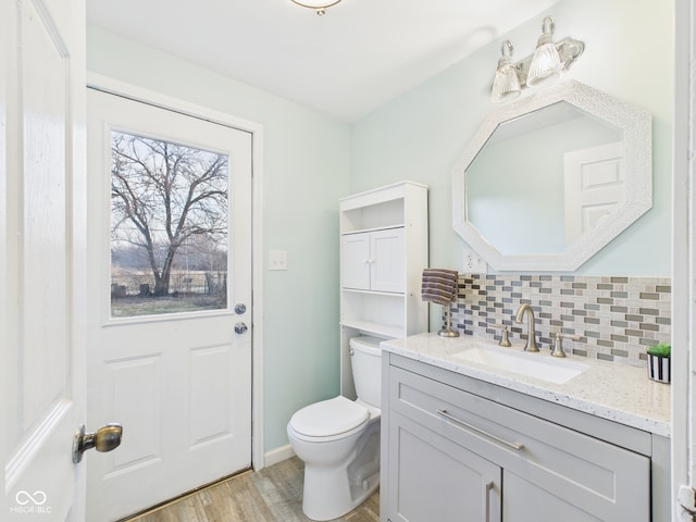 bathroom featuring tasteful backsplash, toilet, vanity, and wood finished floors