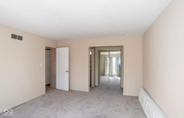 spare room with carpet, visible vents, and baseboards