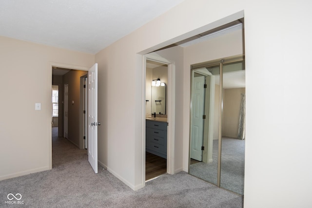 corridor featuring baseboards and carpet flooring