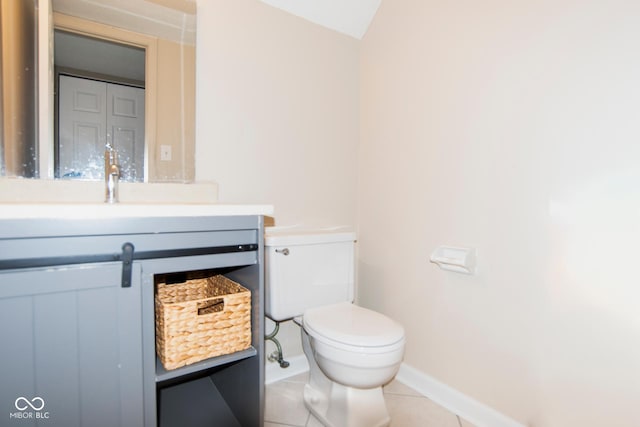 half bathroom with tile patterned flooring, toilet, vanity, and baseboards