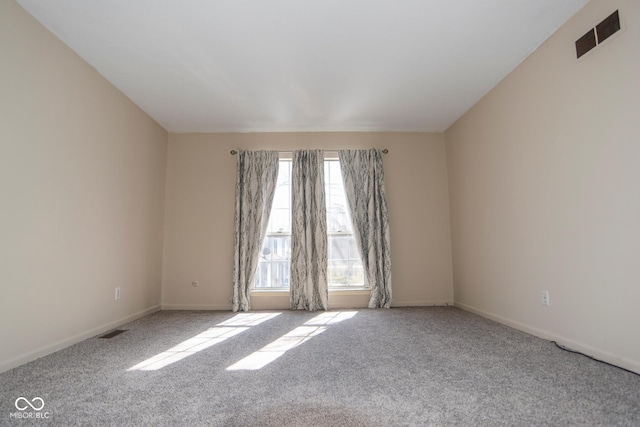 carpeted empty room featuring visible vents and baseboards