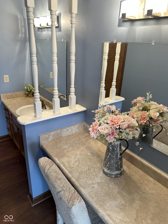 bathroom featuring baseboards, wood finished floors, and vanity