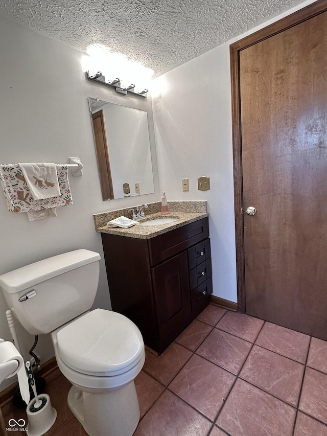 half bath featuring tile patterned floors, toilet, a textured ceiling, baseboards, and vanity