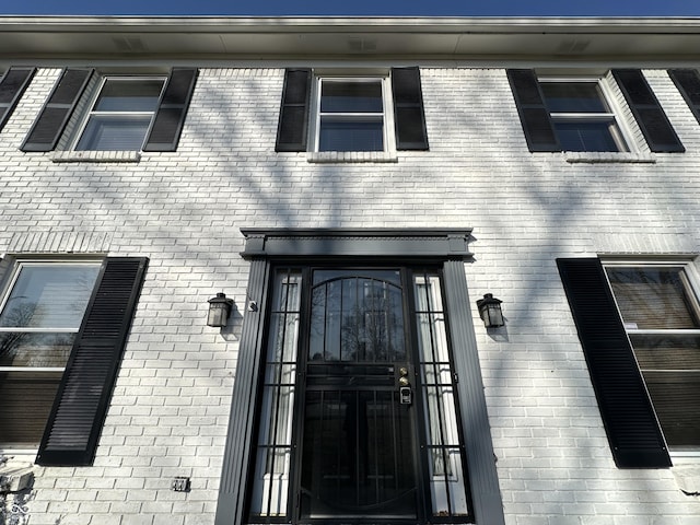 doorway to property featuring brick siding