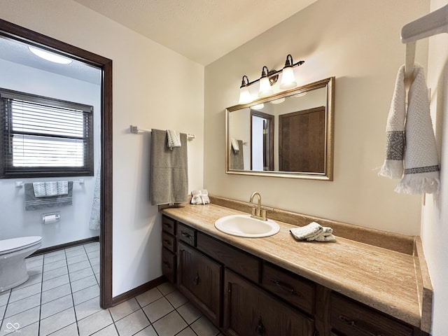 bathroom featuring tile patterned flooring, toilet, vanity, and baseboards